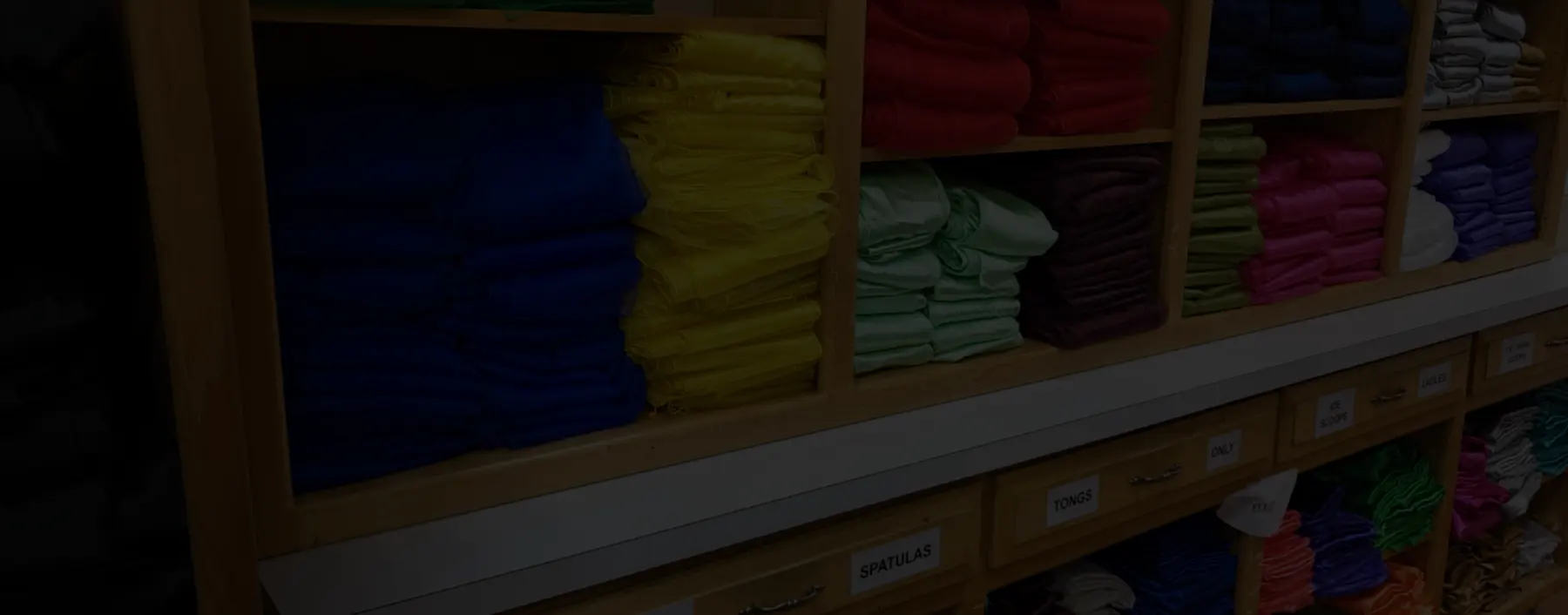 Shelves of folded table linens in a range of colors