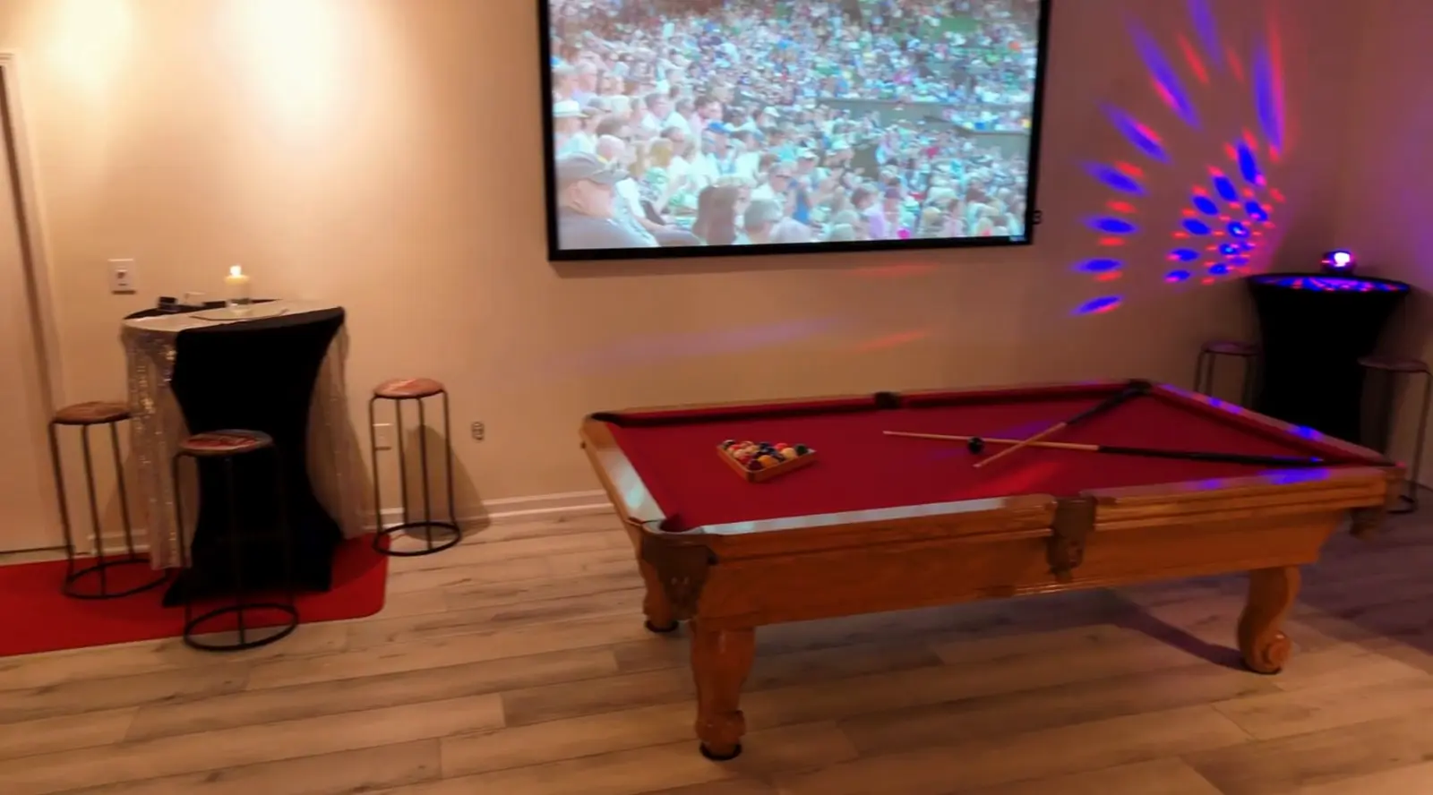 The private lounge with a pool table and projector screen