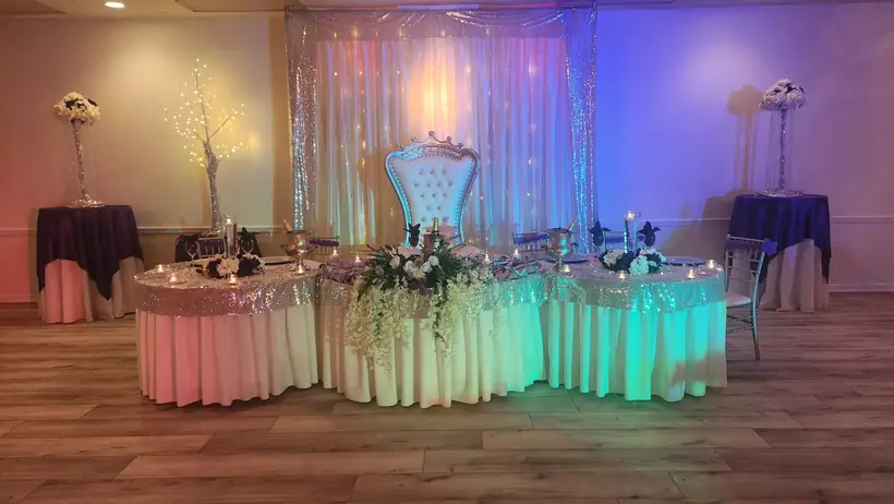 The head table and throne chair in front of a sequin backdrop