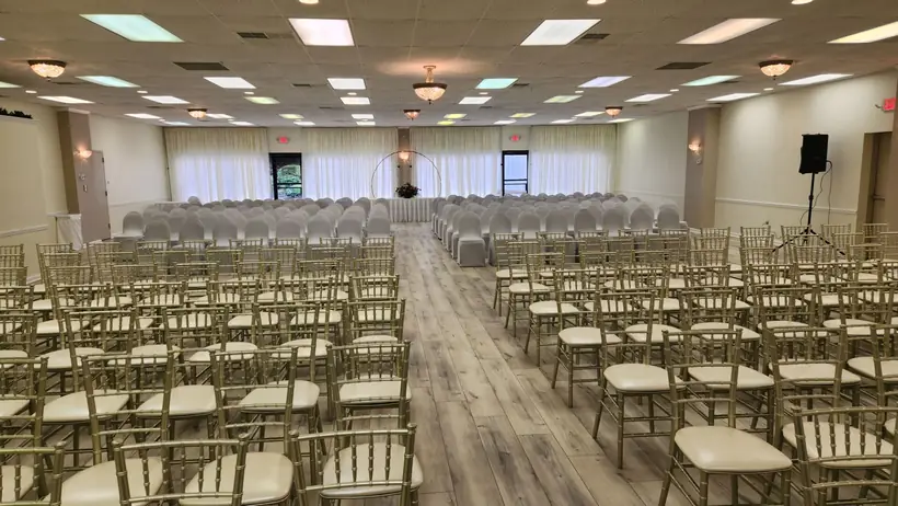 Ceremony rows of gold chairs facing the front of the hall