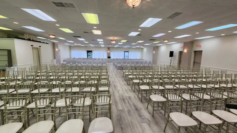 Rows of gold chairs on both sides of a center aisle, set for a ceremony