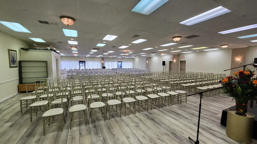 Ceremony rows seen from the side of the room, with florals by the podium