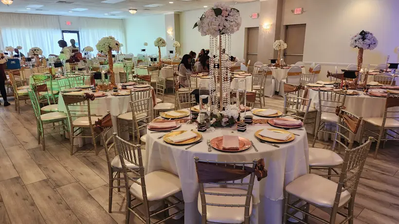 Reception tables with tall floral centerpieces and gold chargers