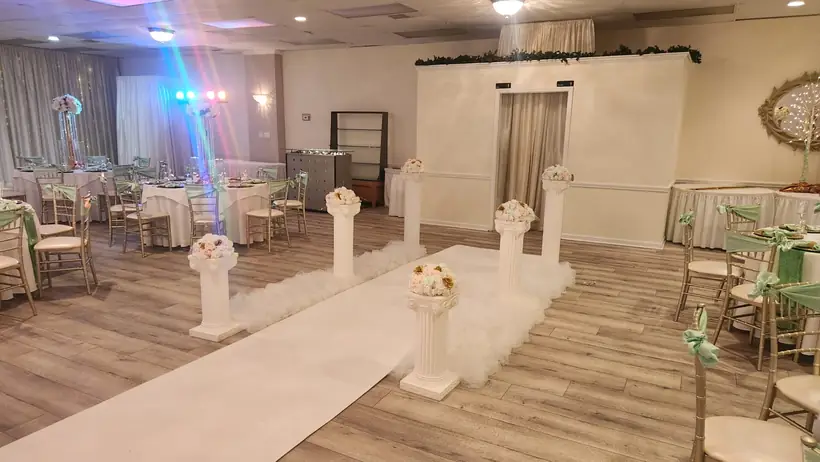 A white aisle runner lined with pillars and florals