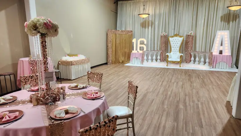 Blush tables facing a sweet sixteen stage with marquee letters