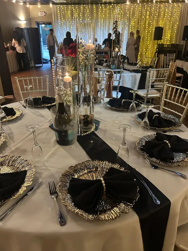 Ivory linens with black runners and gold-rimmed chargers