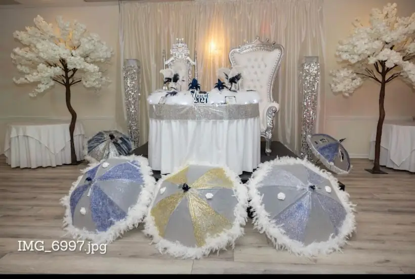 A Class of 2021 head table with a silver throne, blossom trees and feathered parasols