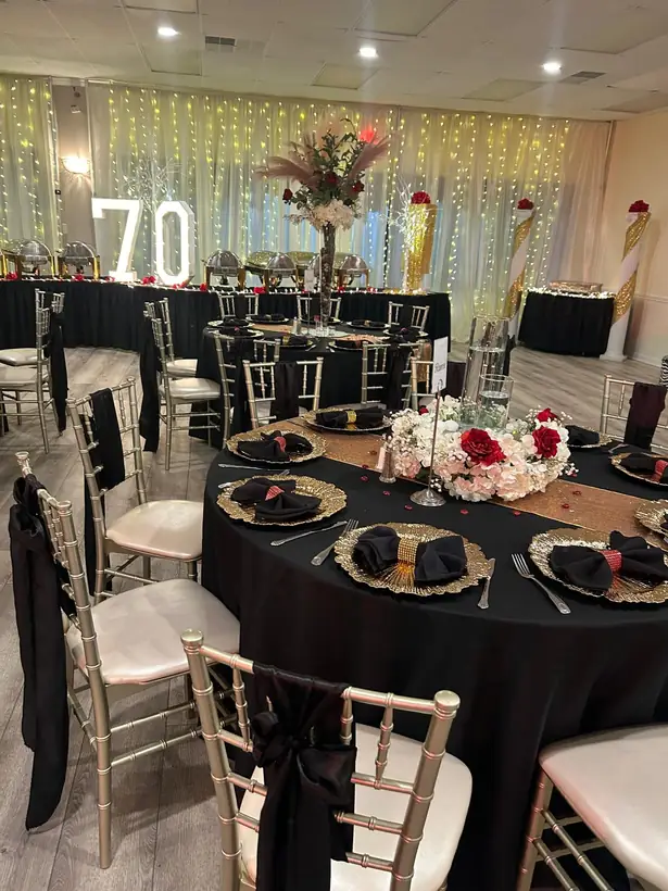 Black and gold tables for a 70th birthday, with marquee numbers behind